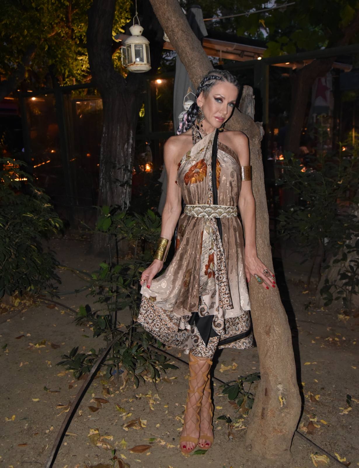 Braided hair and printed halter dress in a garden bar