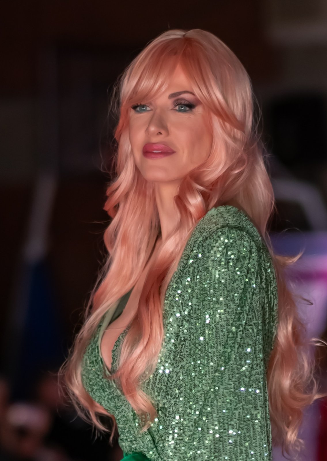 Peach waves with a green sequin gown on the runway