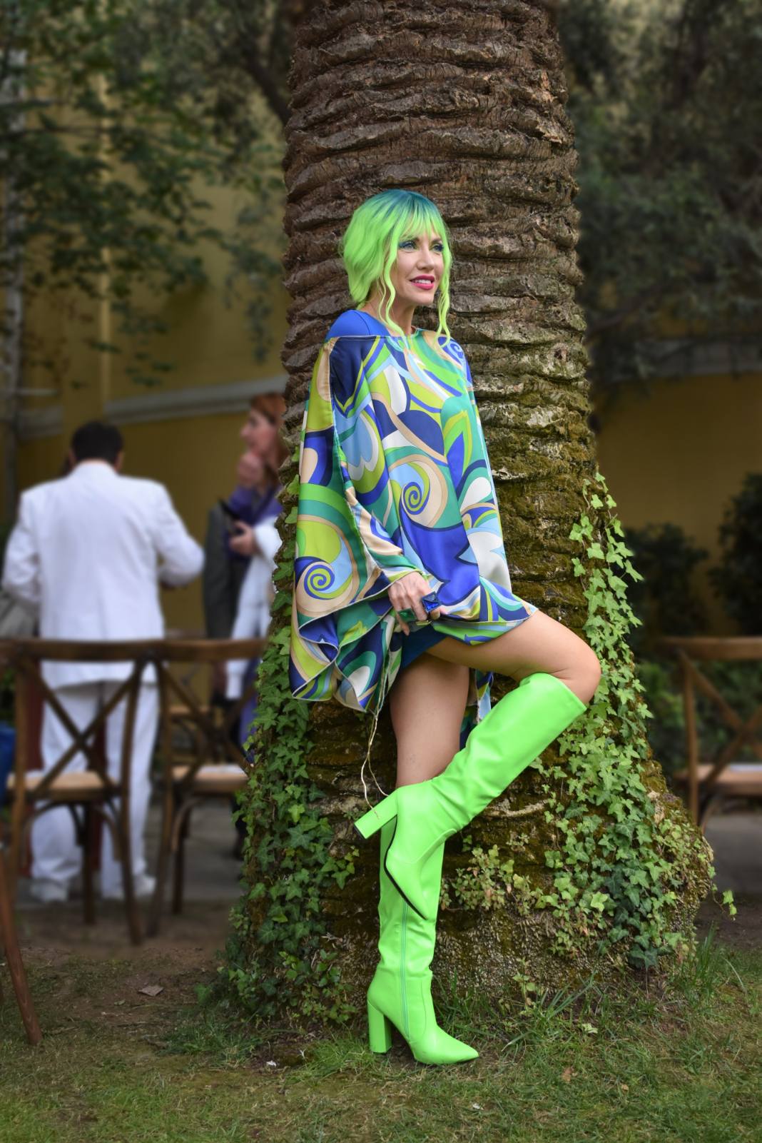 Neon green hair and boots beside a palm trunk