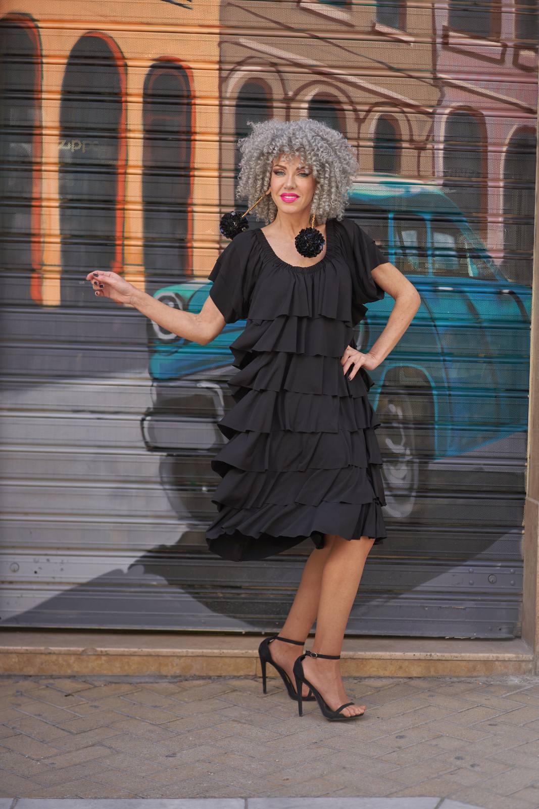 Black tiered ruffle dress against a vintage car mural
