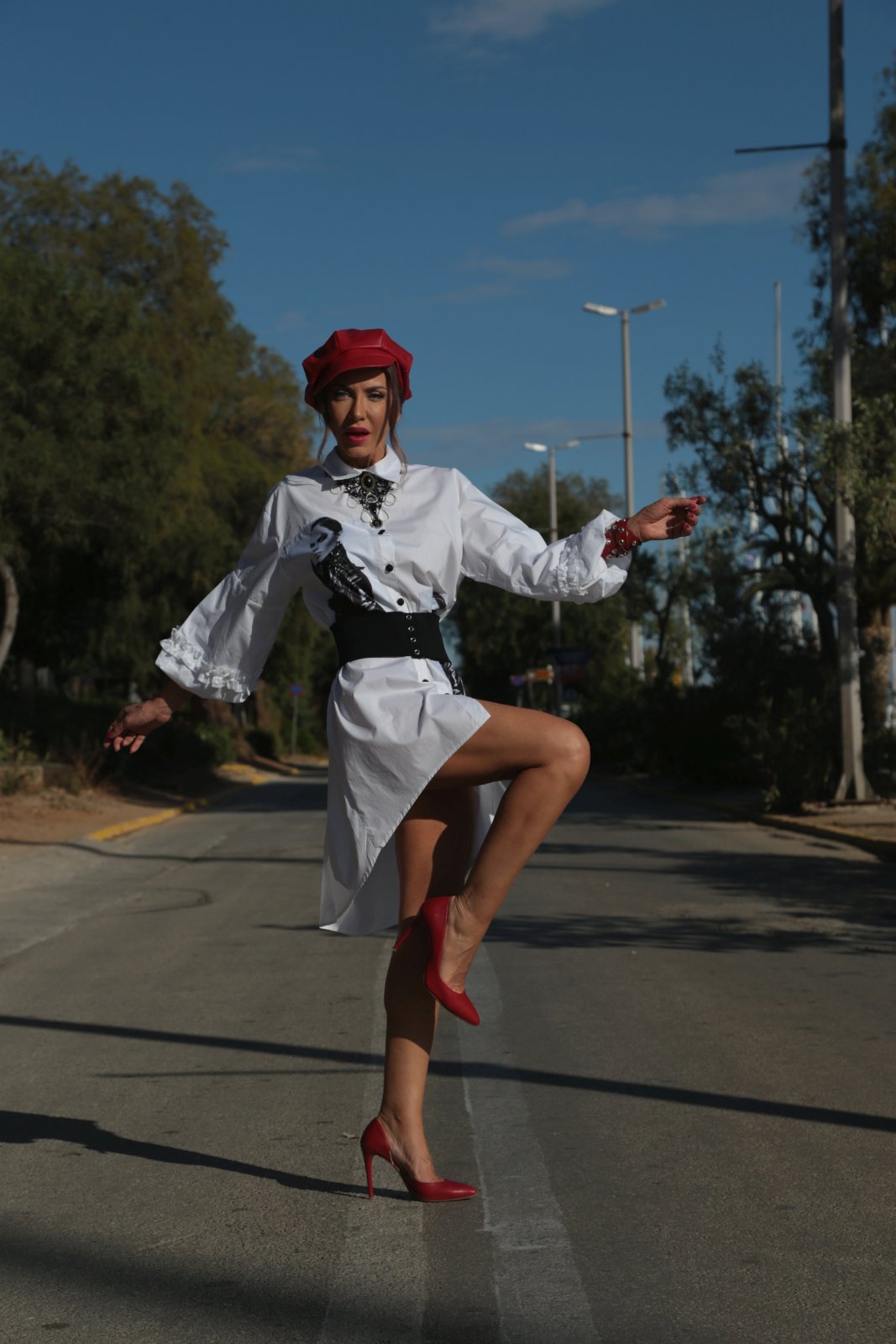 White shirt dress with red beret and heels on an open road