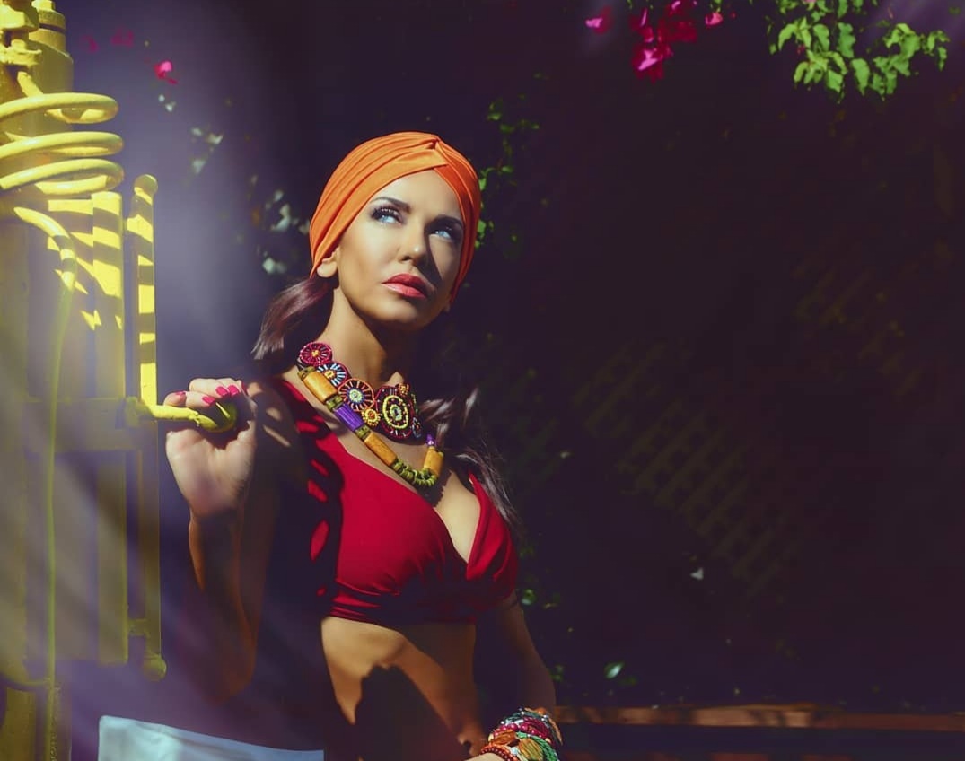 Orange turban and red bustier under bougainvillea