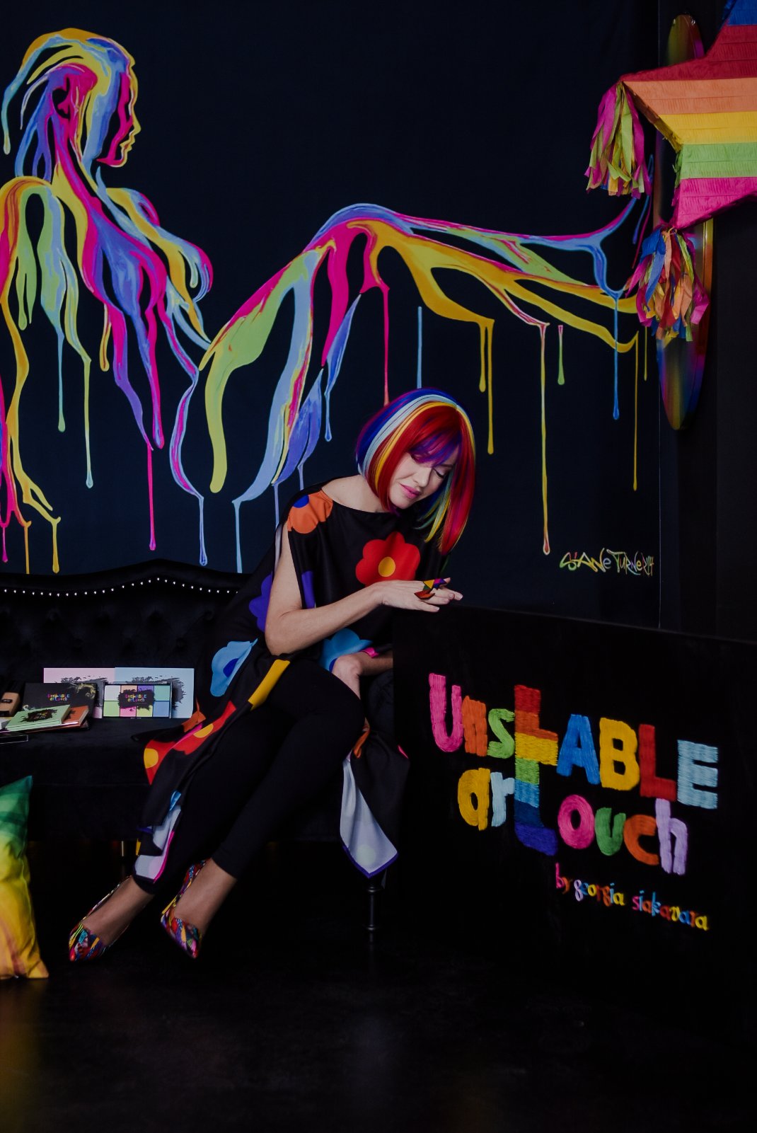 Georgia Siakavara in a rainbow bob wig inside the Unstable Art Touch studio