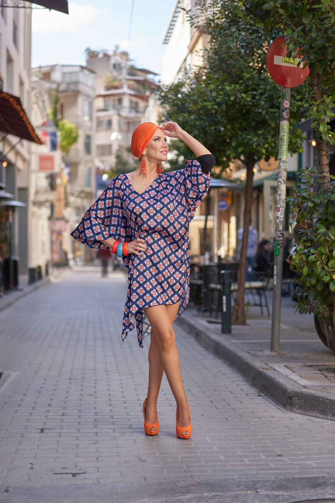 Orange turban with a geometric print kaftan on a city street